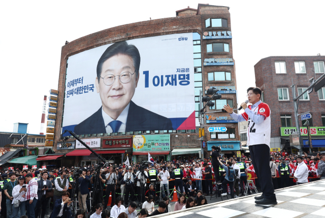 국민의힘 김문수 대선 후보가 14일 경남 밀양시 밀양관아 앞에서 유세하고 있다. 이재명 더불어민주당 대선 후보 대형 현수막이 밀양관아 맞은편 건물 외벽을 다 채웠다. 연합뉴스