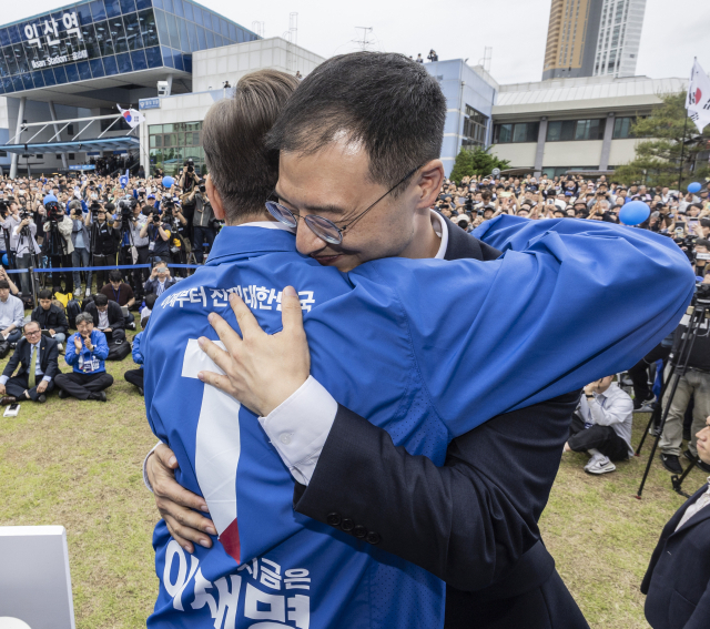 더불어민주당 이재명 대선후보가 16일 전북 익산시 익산역 동부광장에서 열린 유세 도중 유세장을 찾은 무소속 김상욱 의원과 포옹하고 있다. 연합뉴스