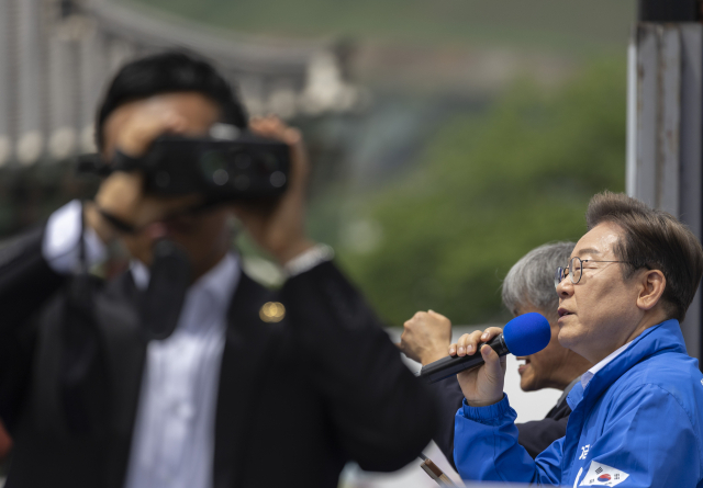 더불어민주당 이재명 대선후보가 17일 전남 나주시 금성관 망화루 앞에서 열린 유세에서 연설을 하는 동안 경호 관계자들이 철저히 사주를 경계하고 있다. 연합뉴스