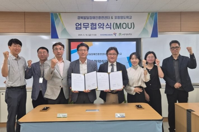 경북발달장애인훈련센터 류재근 센터장, 포항명도학교 전용석 학교장이 협약서에 서명한 후 참석자들과 기념촬영을 하고 있다. 경북발달장애인훈련센터 제공