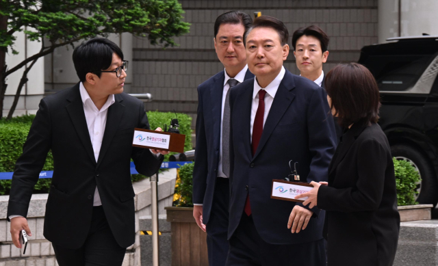 윤석열 전 대통령이 19일 서울 서초구 중앙지방법원에서 열린 내란 우두머리 혐의, 직권남용 권리행사방해 혐의 사건 4차 공판에 출석, 취재진의 질문을 받으며 이동하고 있다. 연합뉴스