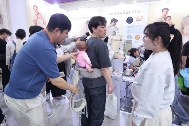1일 서울 강남구 코엑스에서 열린 2025 코베 베이비페어에서 관람객들이 아기띠를 착용해보고 있다. 사진은 기사와 관련 없음. 연합뉴스