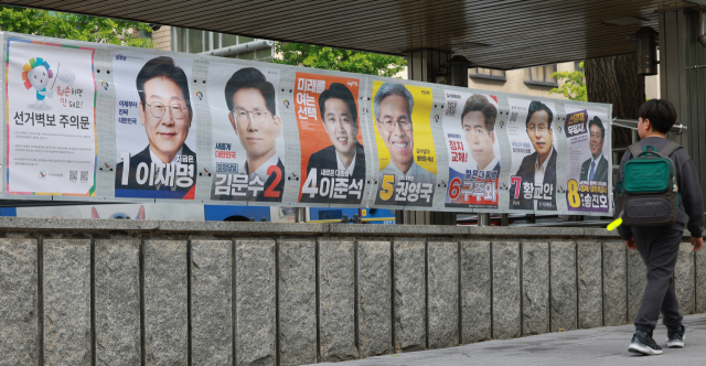 15일 서울 지하철 3호선 무악재역 4번 출구에 첩부된 제21대 대통령 선거 벽보를 어린이가 보며 지나가고 있다. 연합뉴스
