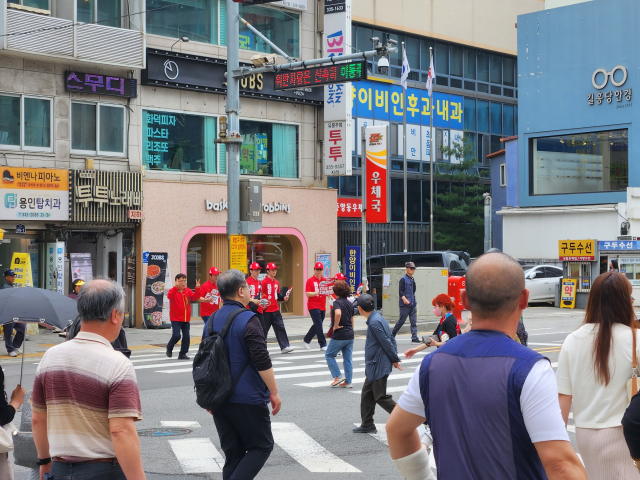 20일 찾은 용인시의 한 교차로. 시민들 사이로 선거운동원이 지나가고 있다. 배주현 기자