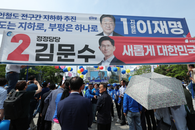 더불어민주당 이재명 대선 후보가 21일 인천광역시 부평역 북광장에서 열린 집중유세에서 인천 시민들에게 지지를 호소하는 가운데 이 후보와 국민의힘 김문수 대선 후보의 현수막이 걸려 있다. 연합뉴스