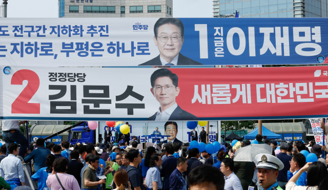 더불어민주당 이재명 대선 후보가 21일 인천광역시 부평역 북광장에서 열린 집중유세에서 인천 시민들에게 지지를 호소하는 가운데 이 후보와 국민의힘 김문수 대선 후보의 현수막이 걸려 있다. 연합뉴스