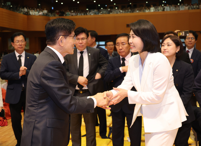 국민의힘 김문수 대선 후보와 더불어민주당 이재명 대선 후보의 배우자 김혜경 여사가 24일 충북 단양군 구인사에서 열린 상월원각대조사 제51주기 열반대재에서 만나 악수하고 있다. 연합뉴스