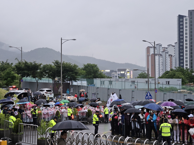 24일 늦은 오후부터 비가 쏟아져, 달성 사저 앞에는 김문수 국민의힘 대선 후보의 박근혜 전 대통령 예방 소식을 듣고 찾아온 시민들의 우산이 진을 이뤘다. 이들은 김 후보가 도착하기 전부터 태극기를 흔들며 김 후보의 이름을 연호하기도 했다. 윤정훈 기자