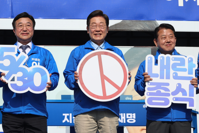이재명 더불어민주당 대선 후보가 26일 경기 남양주시 평내호평역 광장에서 열린 유세에서 사전투표를 독려하는 패널을 들어 보이고 있다. 연합뉴스