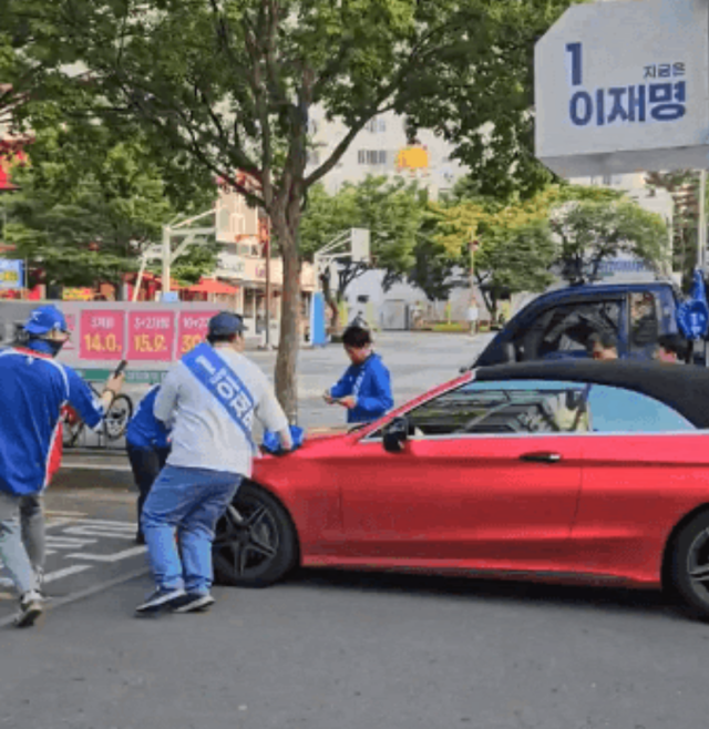26일 오후 대구시 수성구 신매역 광장 인근에서 더불어민주당 유세 현장을 향해 경적을 울린 자동차가 운동원들에게 둘러쌓여있다. 독자 제공