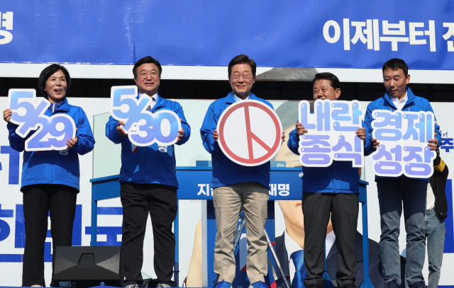 더불어민주당 이재명 대선 후보가 26일 경기 남양주시 평내호평역 광장에서 열린 유세에서 사전투표를 독려하는 패널을 들어 보이고 있다. 연합뉴스