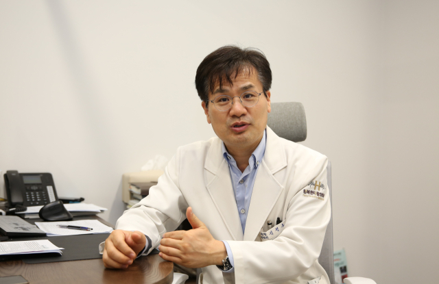 김정훈 행복한H병원 원장이 진료실에서 맨발걷기에 대한 이야기를 들려주고 있다. 김도훈 기자