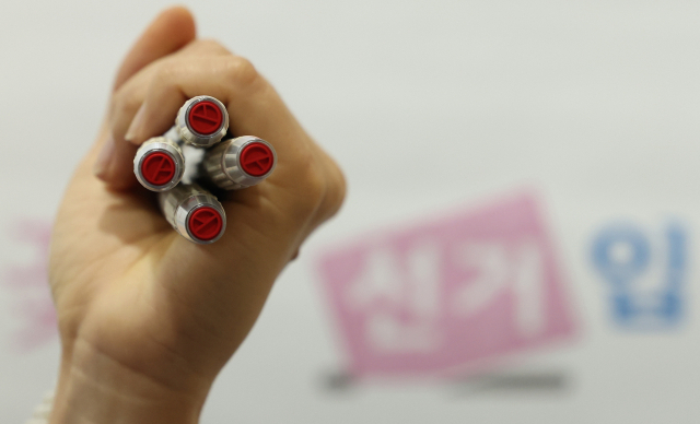 제21대 대통령선거 사전투표를 하루 앞둔 28일 서울 관악구 신사동 복합청사에 마련된 사전투표소에서 관계자가 기표 도장을 들어 보이고 있다. 연합뉴스