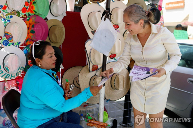 멕시코 치와와주(州)의 한 판사 후보자가 한 상인에게 지지를 호소하고 있다. 연합뉴스