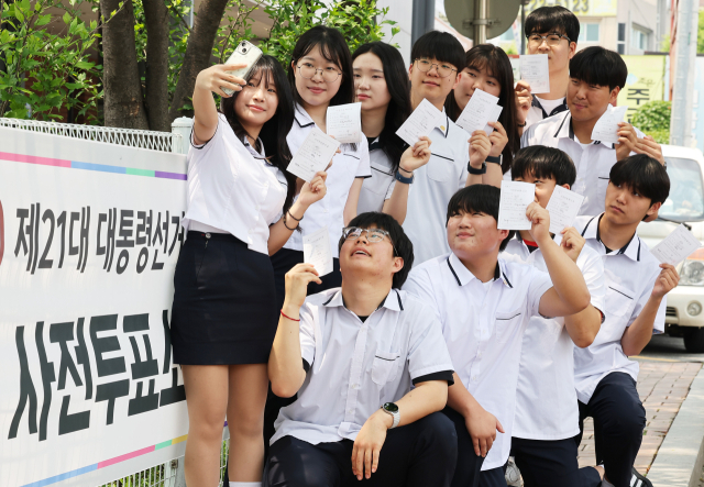 제21대 대통령선거 사전투표 첫날인 29일 경기도 수원시 장안구 연무동행정복지센터에 마련된 투표소에서 투표를 마친 삼일공업고등학교 3학년 학생들이 투표확인증을 들고 인증사진을 찍고 있다. 연합뉴스