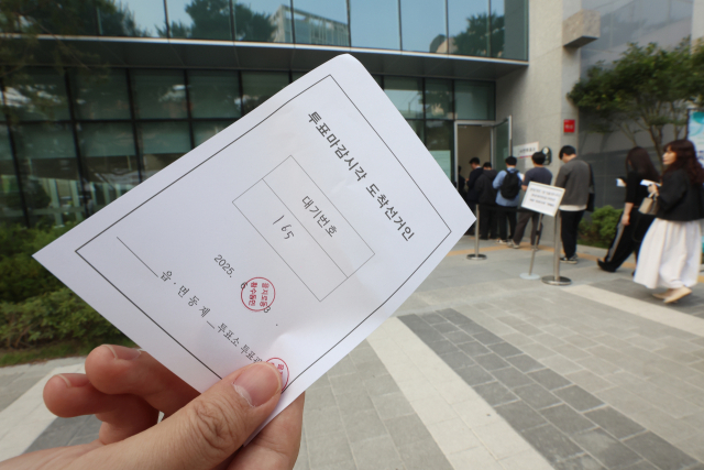 제21대 대통령선거 사전투표 둘째 날인 30일 서울 중구 을지누리센터에 마련된 사전투표소에서 투표 종료 이후에도 투표하지 못한 한 유권자가 대기표를 들고 투표 순서를 기다리고 있다. 연합뉴스