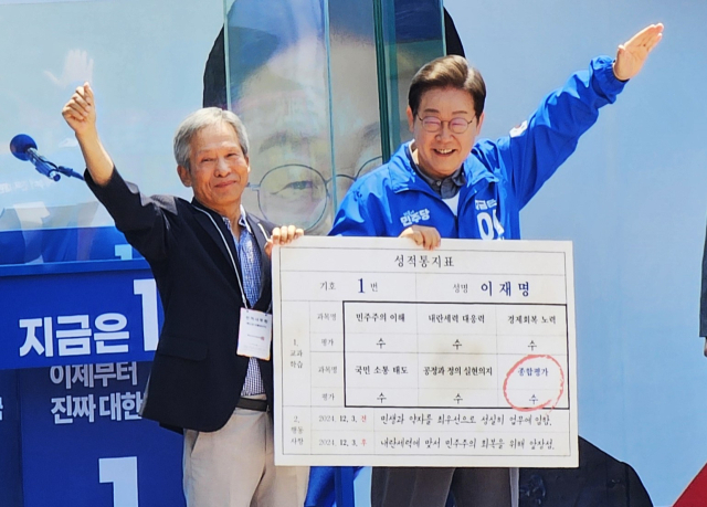 이재명 더불어민주당 대선후보가 1일 안동 웅부공원에서 초등학교시절 담임교사였던 박병기 씨와 성적표를 들고 미소 짓고 있다. 엄재진 기자