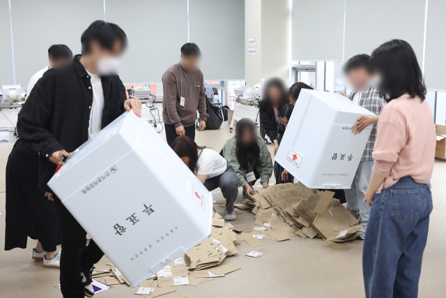 제21대 대통령선거 사전투표 둘째 날인 30일 서울 중구 을지누리센터에 마련된 사전투표소에서 사전투표사무원들이 참관인 및 공정선거참관단이 지켜보는 가운데 관외투표함을 열고 있다. 연합뉴스