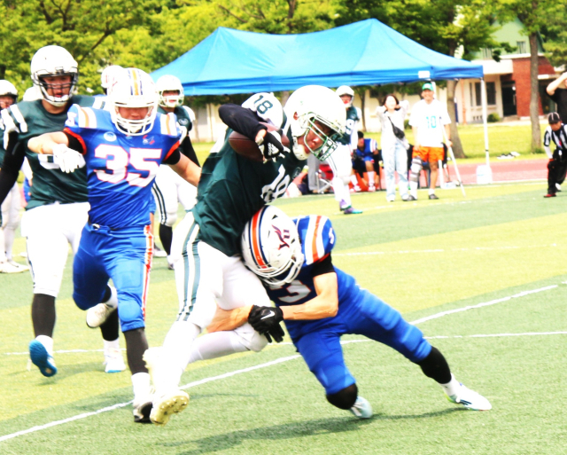 영남대 수비수 권지훈(3번)이 지난달 30일 영남대 구장에서 열린 대구경북 대학 미식축구 춘계리그 2부 경기 도중 대구대 리시버 김진호(18번)를 저지하기 위해 강력한 태클을 시도하고 있다. 대구경북 미식축구협회 제공