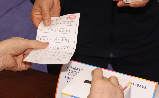 제21대 대통령선거일인 3일 오전 제주시 연동 제1투표소가 마련된 제주도의회 의원회관에서 한 유권자가 투표용지를 배부받고 있다. 연합뉴스