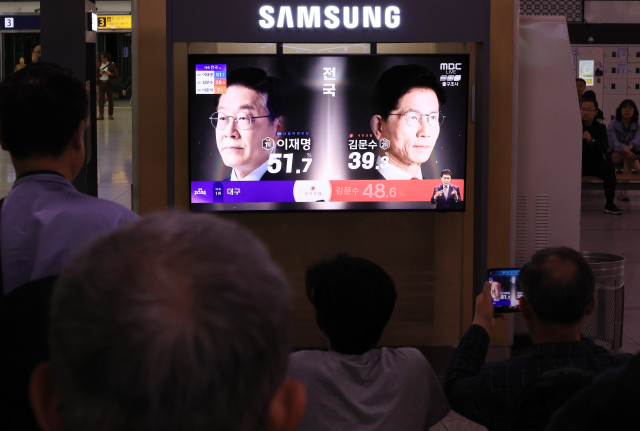 제21대 대통령선거가 치러진 3일 서울역 대합실에서 시민들이 TV를 통해 선거 출구조사 결과 발표 방송을 지켜보고 있다. 연합뉴스