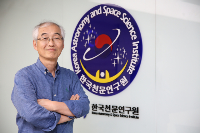 전영범 책임연구원이 한국천문연구원 엠블럼 앞에서 포즈를 취하고 있다. 김도훈 기자
