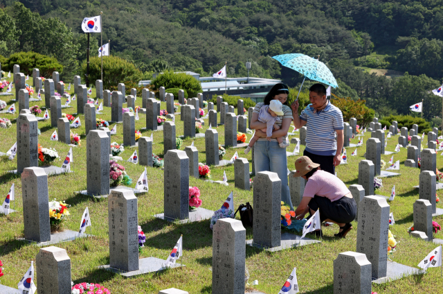 현충일을 하루 앞둔 5일 국가유공자, 참전 군인 등 호국영령들의 유해가 안치돼 있는 국립영천호국원을 찾은 유족들이 참배를 하고 있다. 김영진 기자 kyjmaeil@imaeil.com