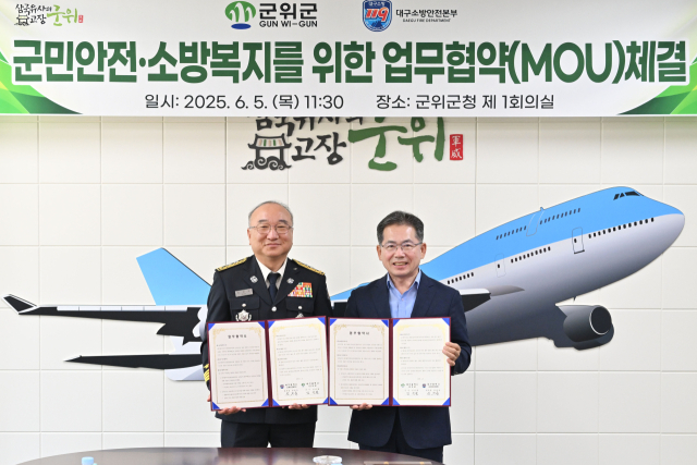 김진열(오른쪽) 대구 군위군수와 엄준욱(왼쪽) 대구소방안전본부장이 군위군청에서 업무협약을 체결하고, 기념 사진을 촬영하고 있다. 군위군 제공