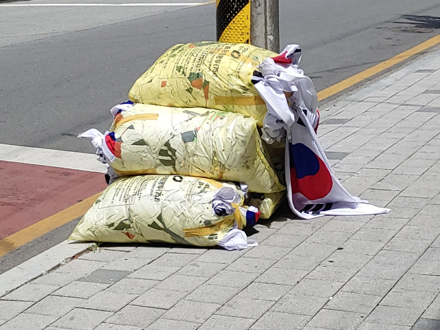 현충일인 6일 충북 청주의 한 도로변에 다량의 태극기가 담긴 쓰레기 종량제 봉투 더미가 발견돼 경찰이 조사에 나섰다. 경찰 등에 따르면 이날 오후 청주시 청원구 내덕동 청주농고 인근에서 주민 A씨는 이 같은 현장을 발견, 지자체 민원 접수처와 경찰에 신고했다. 연합뉴스