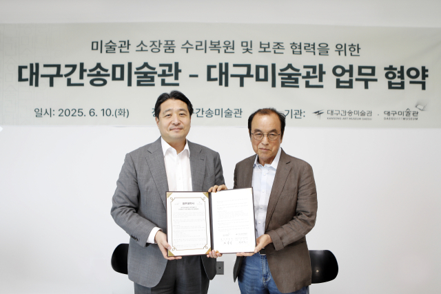 노중기(오른쪽) 대구미술관장과 전인건 대구간송미술관장이 협약서를 들어보이고 있다. 대구시 제공