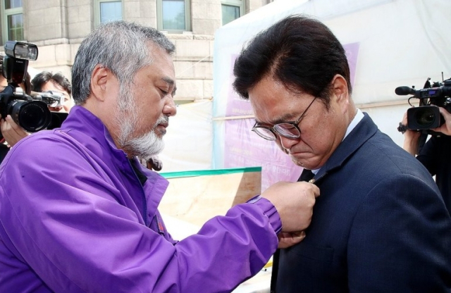 지난해 5월 17일 당시 22대 전반기 국회의장 후보로 선출된 상황이었던 우원식 더불어민주당 국회의원이 당일 서울광장에 마련된 이태원 참사 희생자 분향소를 찾아 10·29이태원참사 유가족협의회 이정민 운영위원장으로부터 뱃지를 받고 있다. 매일신문DB