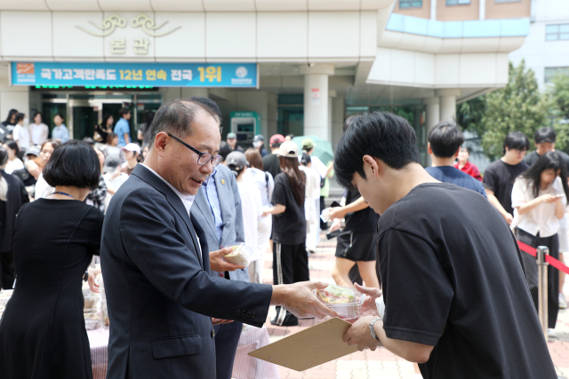 이재용 영남이공대 총장이 샌드위치를 학생들에게 나눠주며 격려의 말을 하고 있다. 영남이공대 제공