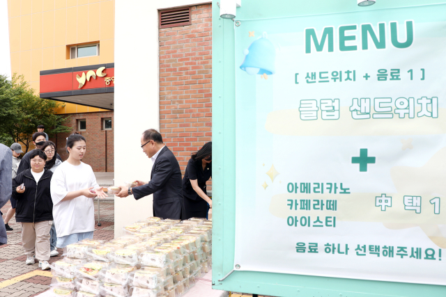 이재용 영남이공대 총장이 샌드위치를 학생들에게 나눠주며 격려의 말을 하고 있다. 영남이공대 제공
