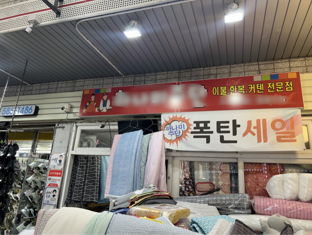 달서구 와룡시장의 한 이불가게가 TV모니터를 이불 걸이로 사용하고 있는 모습. 정두나 기자.