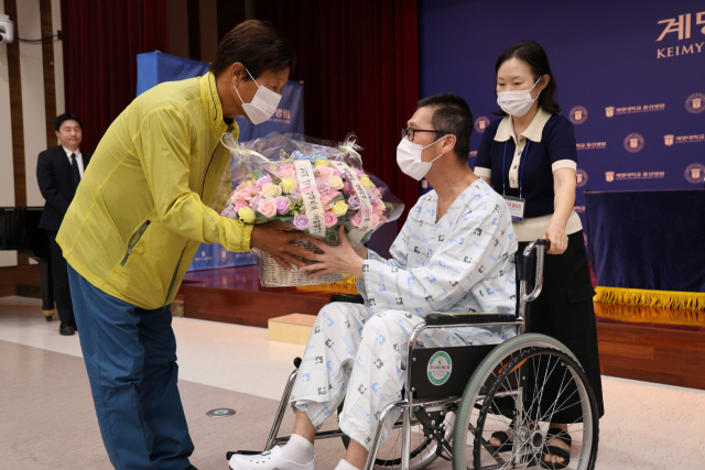 계명대동산병원에서 심장이식 수술을 받은 첫 번째 환자가 100번째 수술을 받은 환자에게 비누꽃을 전달하고 있다. 계명대동산의료원 제공.