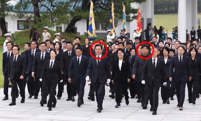 당 대표 출마를 선언한 더불어민주당 정청래 의원(왼쪽 빨간 원)이 16일 서울 동작구 국립서울현충원 현충탑을 참배하기 위해 이동하고 있다. 오른쪽 빨간 원은 동행한 양문석 의원. 연합뉴스