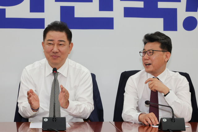 더불어민주당 김병기 당대표 직무대행 겸 원내대표(왼쪽)가 19일 서울 여의도 국회에서 열린 정책조정회의에서 진성준 정책위의장에게 손뼉 치고 있다. 연합뉴스