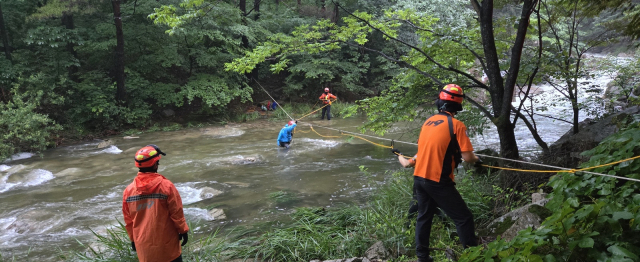 지난 21일 문경새재 조령산에서 문경소방서 119 구조대가 불어난 계곡물에 고립됐던 등산객들을 구조하고 있다. 문경소방서 제공