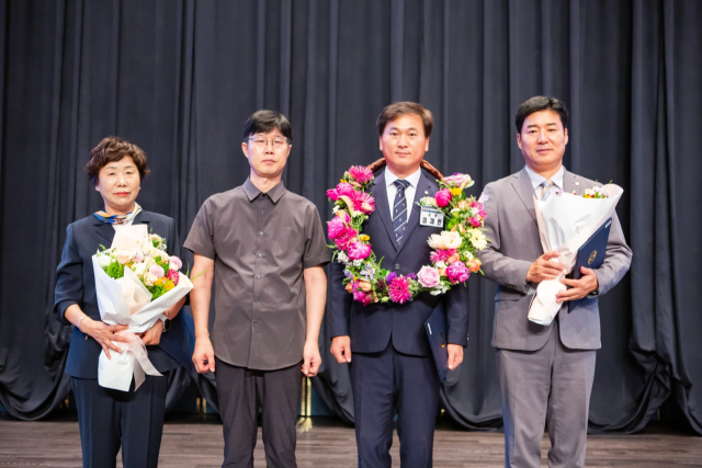 연임에 성공한 이재만 대구지방세무사회장이 꽃다발을 목에 걸고 기념촬영을 하고 있다.