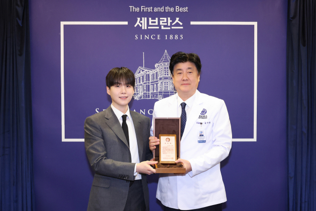 그룹 방탄소년단의 슈가(왼쪽)와 금기창 연세의료원장이 기념 촬영하는 모습. 연합뉴스