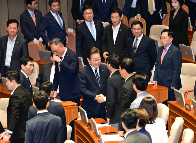 이재명 대통령이 26일 국회 본회의장에서 추가경정예산 시정연설을 마친 뒤 국민의힘 의원들과 악수하고 있다. 연합뉴스