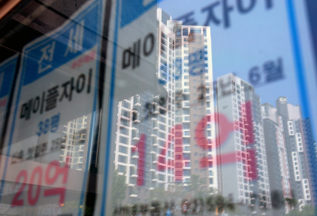 최근 급격한 서울 집값 상승으로 서울 평균 전세가율(매매가격 대비 전세가격비율)은 8년여 만에 최저치를 기록한 가운데 23일 서울 시내 한 부동산에 붙은 전세 매물 안내문에 인근 아파트 모습이 비치고 있다.연합뉴스