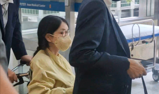 특별검사팀 출범을 앞두고 우울증 등 지병을 이유로 입원했던 김건희 여사가 27일 서울 송파구 서울아산병원에서 윤석열 전 대통령이 미는 휠체어에 탄 채 퇴원하고 있다. 연합뉴스