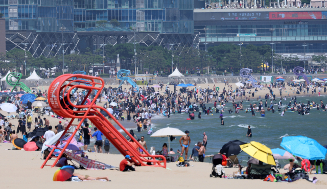 29일 오후 부산 해운대해수욕장에서 피서객들이 물놀이를 하며 더위를 식히고 있다. 이날 전국적으로 무더위가 기승을 부린 가운데 부산 일부 지역도 34도를 기록했다. 연합뉴스