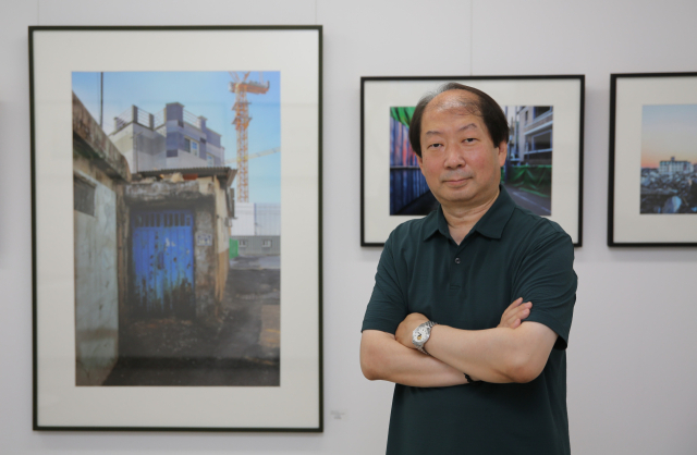 박정일 사진가가 자신의 작품 앞에서 포즈를 취하고 있다. 김도훈 기자