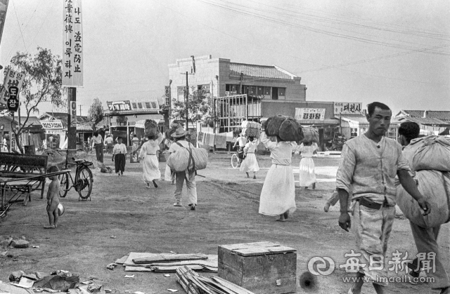 1961년 7월 11일 폭우로 집을 잃은 수재민들이 살림살이를 챙겨 임시 수용소로 가고 있다. 사진=매일아카이빙센터