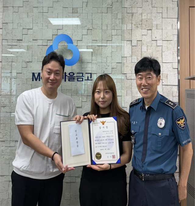 보이스피싱 범죄를 막은 행복새마을금고 성담지점 오은진(가운데) 씨가 성서경찰서로부터 받은 감사장을 내보이고 있다. 행복새마을금고 성당지점 제공