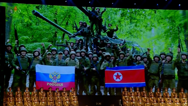 북한이 지난달 29일 평양 4.25문화회관에서 방북 중인 올가 류비모바 러시아 문화부 장관이 참석한 가운데 열린 예술인 공연 중 무대 배경화면에 러시아 파병 북한 군인들의 활동 모습 사진을 조선중앙TV가 30일 내보냈다. [조선중앙TV화면] 연합뉴스
