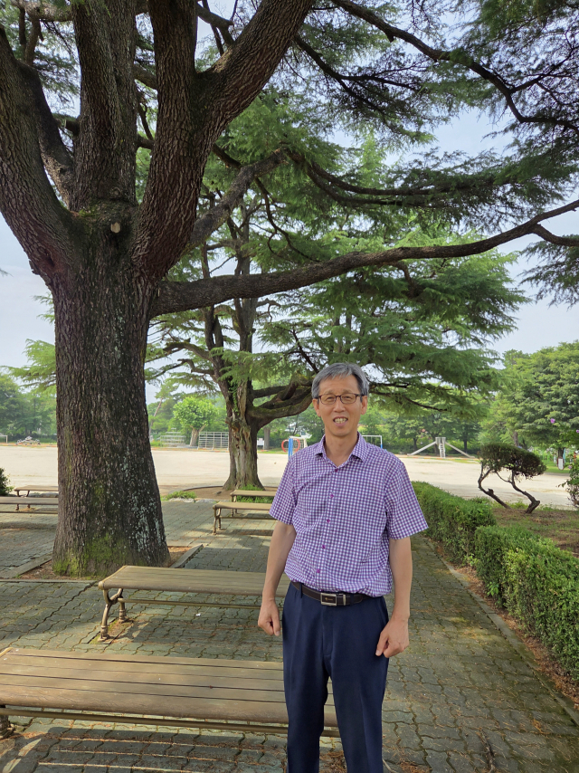 이태운 구미 산동초 교장이 이 학교의 상징인 히말리야시다(개잎갈나무) 아래에서 사진을 찍고 있다. 조규덕 기자