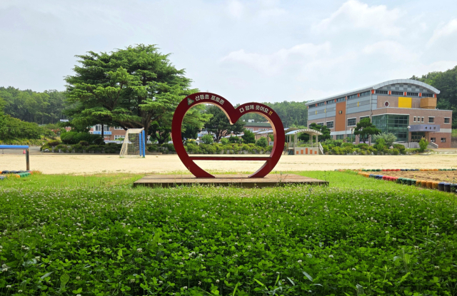 구미 산동초등학교 운동장, 토끼풀 밭 위로 자리한 붉은 하트 포토존이 시선을 사로잡고 있다. 조규덕 기자